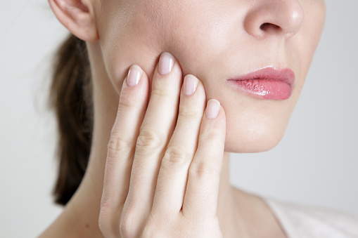 Woman pressing at her aching jaw